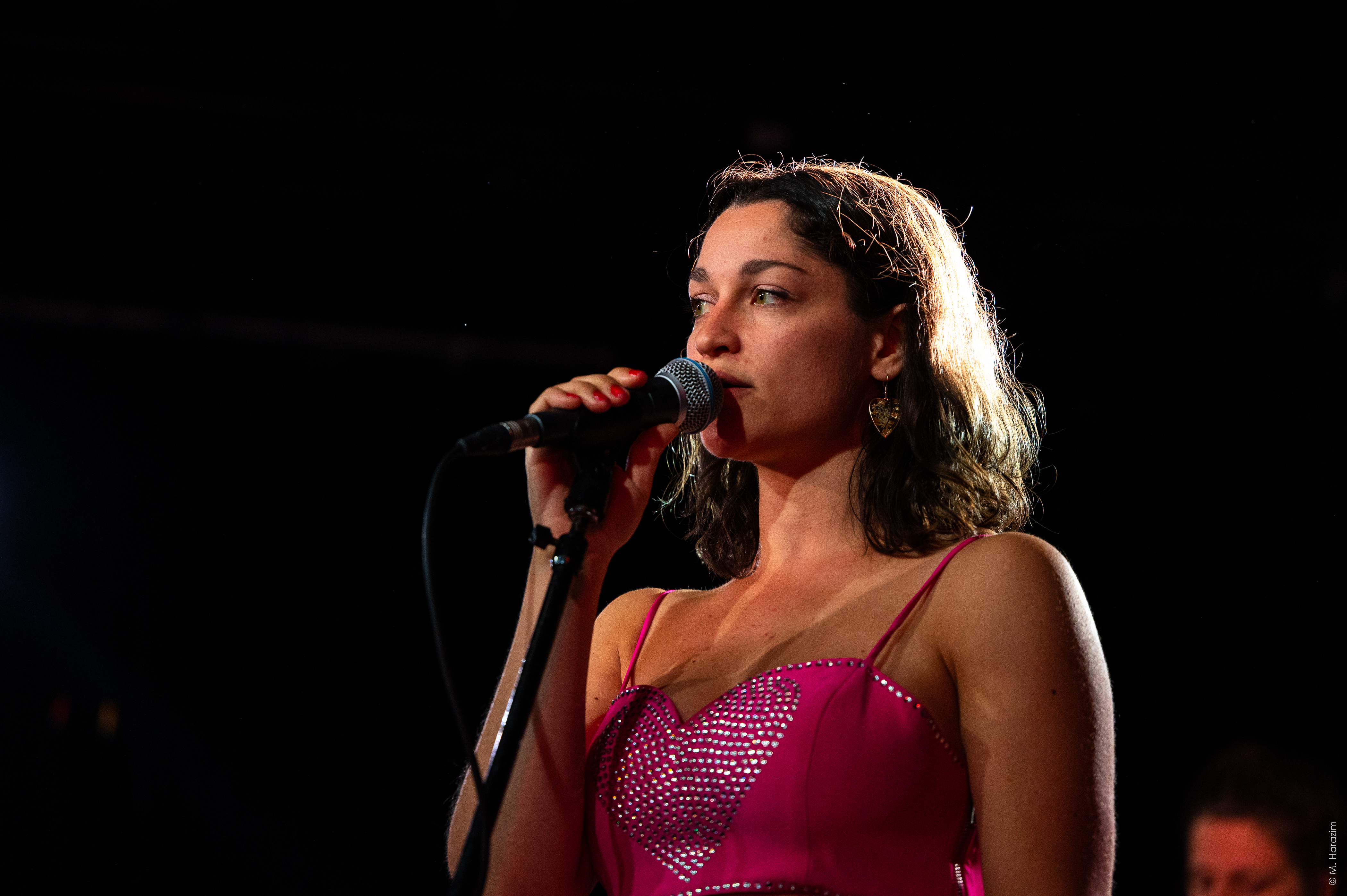 mara cara performing on stage with a pink top